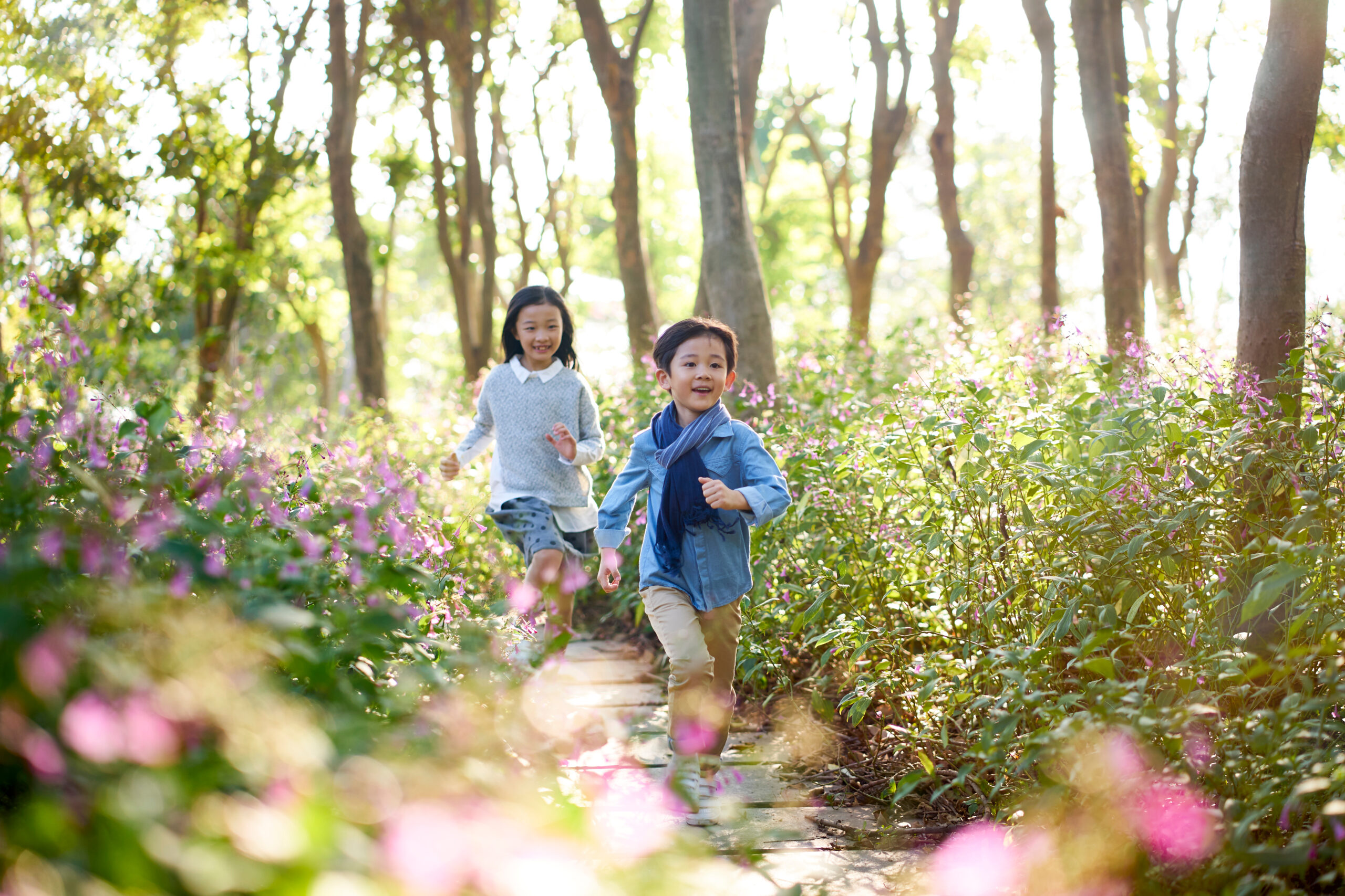 Two,Little,Asian,Children,Boy,And,Girl,Running,Through,Field