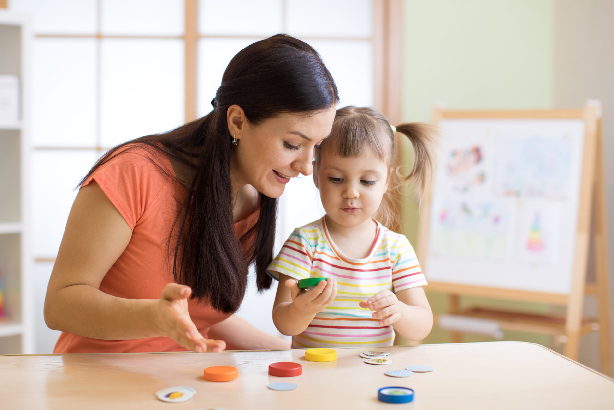 Woman,Teacher,Play,With,Preschooler,Child,In,Day,Care,Center.